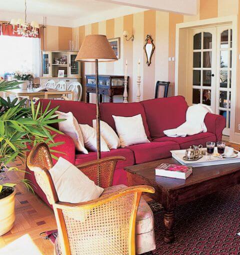 W salonie stoi duża miękka kanapa. Przytulne wnętrze domu w stylu rystykalnym