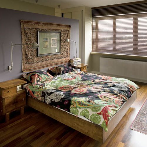 Drewniane, solidne łóżko i bajecznie kolorowa pościel.