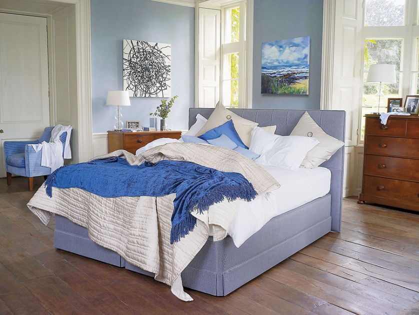 Łóżko Servant (14 100 zł) obite błękitną tkaniną z dopasowaną kolorystycznie pościelą.
